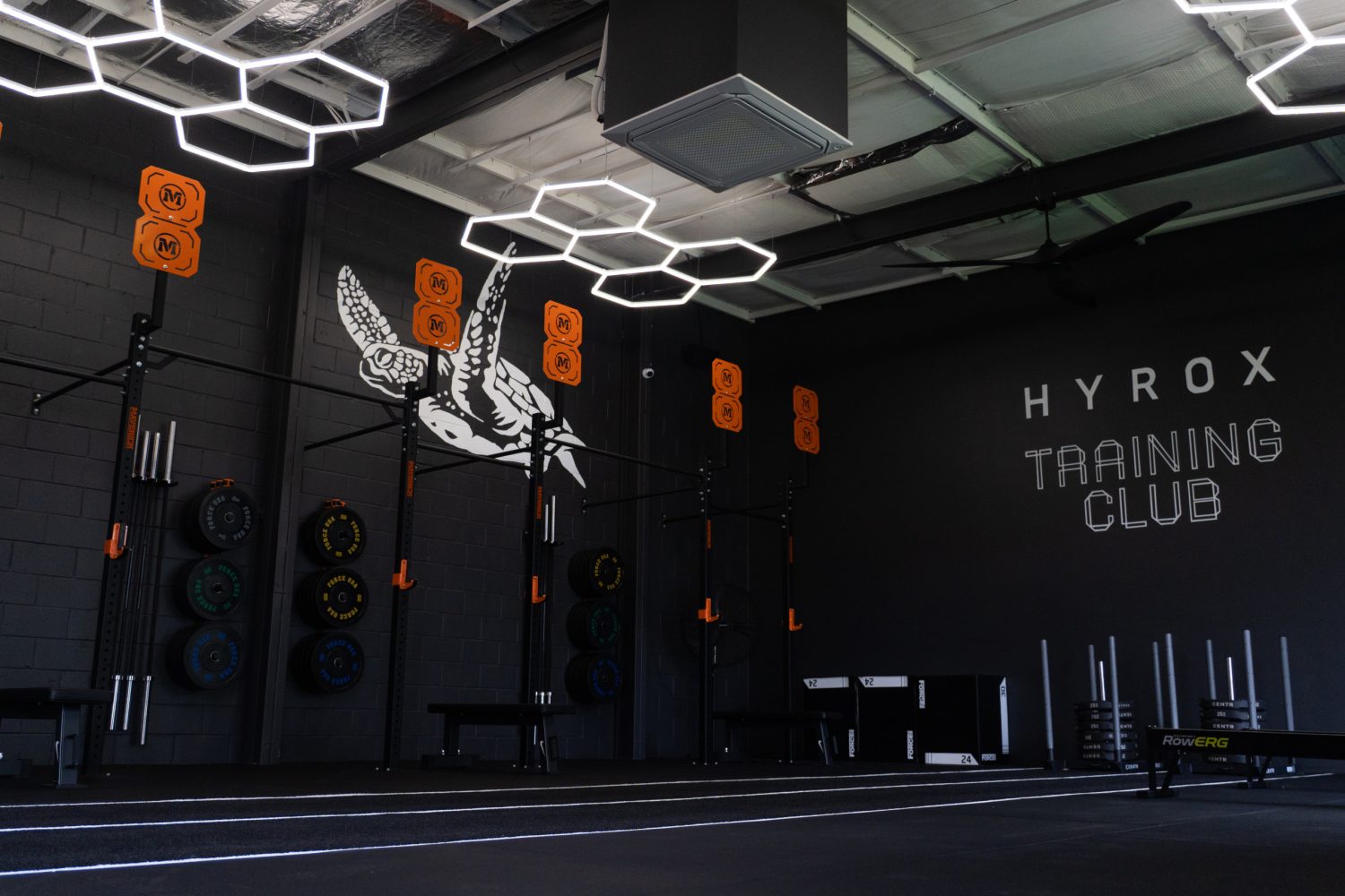 The Hubs training floor with the HYROX Training Club wall
